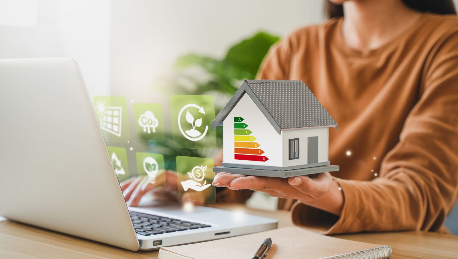 mano sujetando una casa con iconos de ahorro de energía